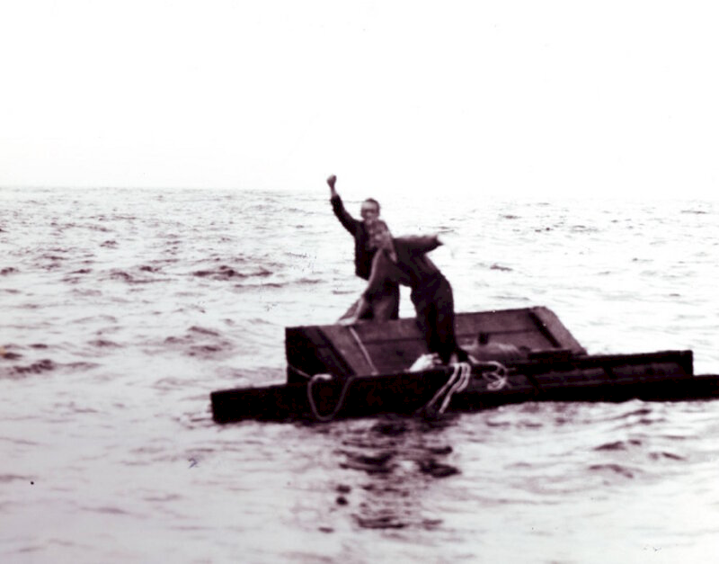 Sailors on wreckage, awaiting rescue